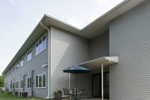 A house with a grey siding and a white roof.