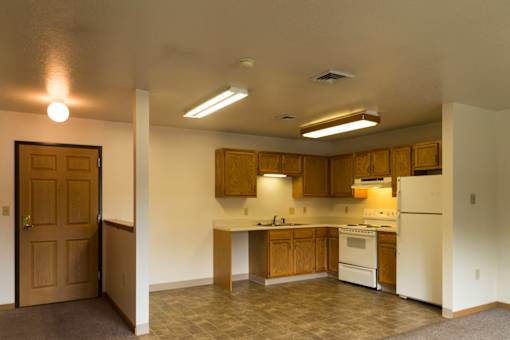 A kitchen with white appliances and wooden cabinets.