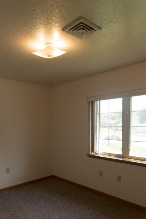 A room with a window and a ceiling light.