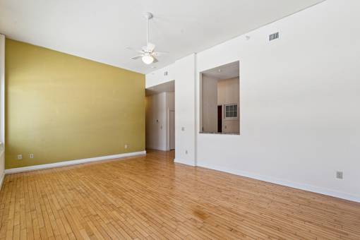 A room with a wooden floor and a ceiling fan.