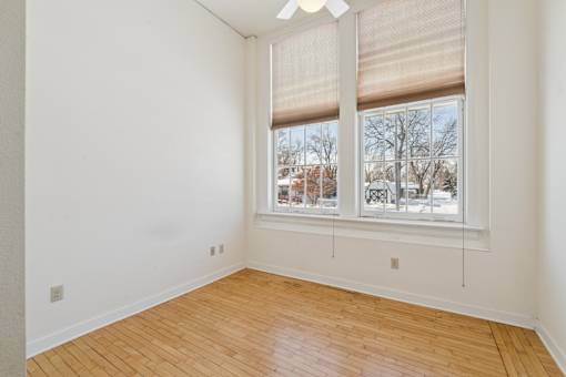 A room with a large window and wooden flooring.