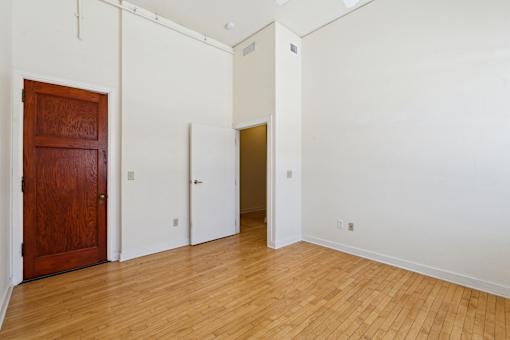 A room with a wooden door and two other doors.