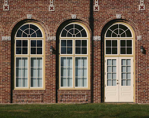 A red brick building with two arched windows and a door.