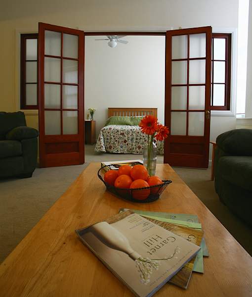 A table with a bowl of oranges and a book on it.