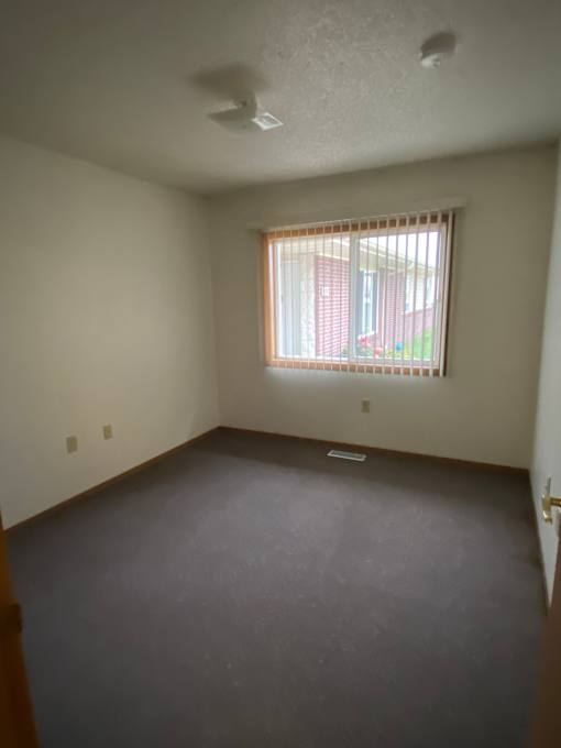 A room with a window and a wall on the right side.