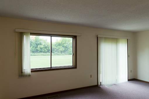 A room with a large window and a closed door.