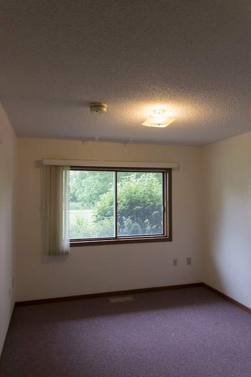 A room with a window and a ceiling light.
