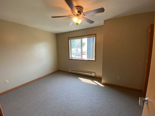 A room with a ceiling fan and a window.