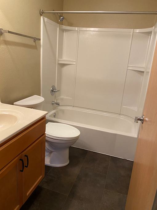 A white toilet is next to a white bathtub in a bathroom.