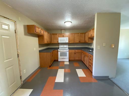 A kitchen with wooden cabinets and a black countertop.