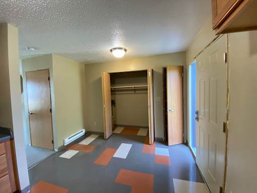 A hallway with a patterned floor and white walls.