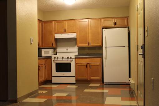 A kitchen with a white fridge, white stove and white microwave.