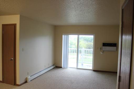 A room with a sliding glass door leading to a balcony.