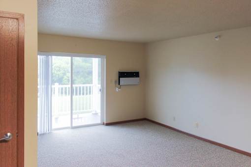 A room with a sliding glass door leading to a balcony.