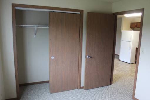 Two brown doors in a room.