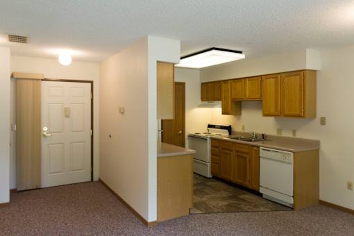 A kitchen area with a sink, stove, and cabinets.