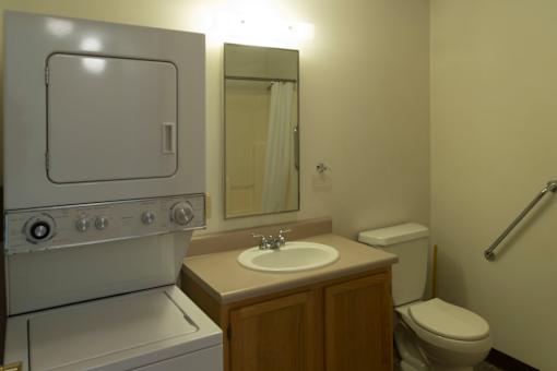 A bathroom with a toilet, sink, and a stove.