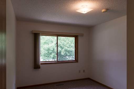 A room with a window and a ceiling light.