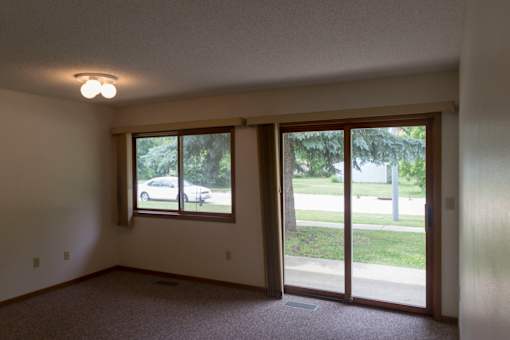 A room with a sliding glass door leading to a backyard.