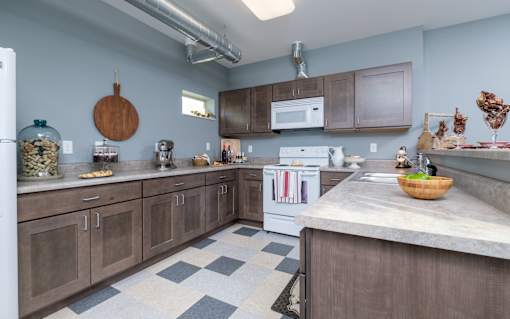 A kitchen with a white refrigerator, a white oven, and brown cabinets.