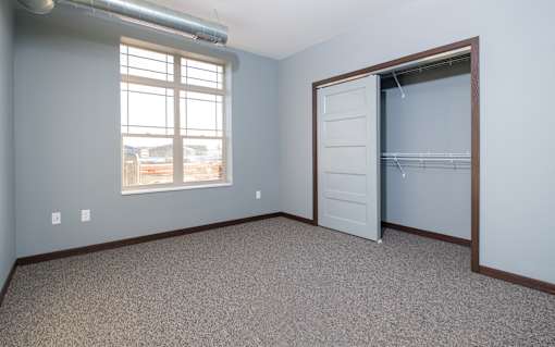 A room with a carpeted floor and a sliding door.