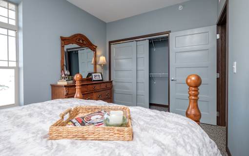 A bedroom with a bed, dresser, and mirror.