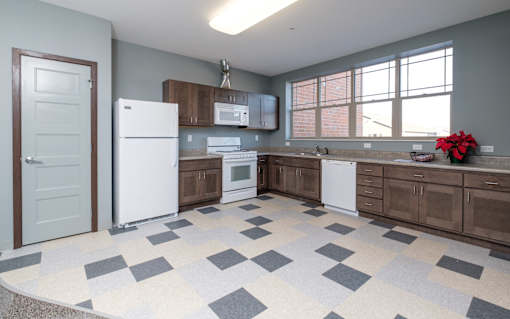 A kitchen with a white fridge, microwave, and dishwasher.