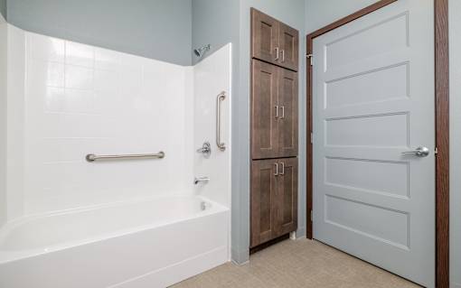 A white bathtub with a silver faucet and shower head in a bathroom.