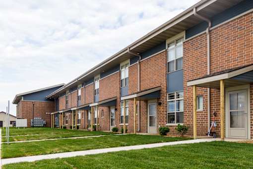 A long brick building with a white trim around the windows and doors.