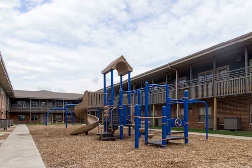A playground with a blue structure and a slide.