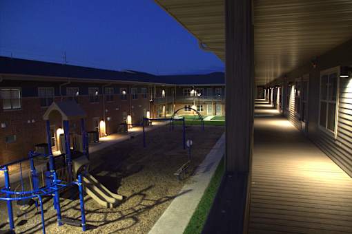A playground area is illuminated by lights at night.