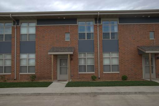A brick building with a grey door and windows.