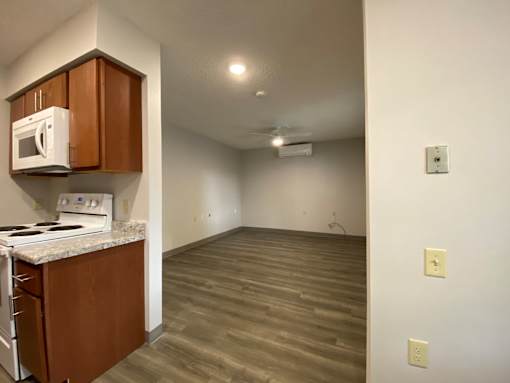 A kitchen with a microwave, oven, and stove top.