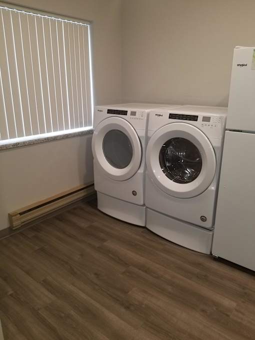 Two front loading washing machines in a laundry room.