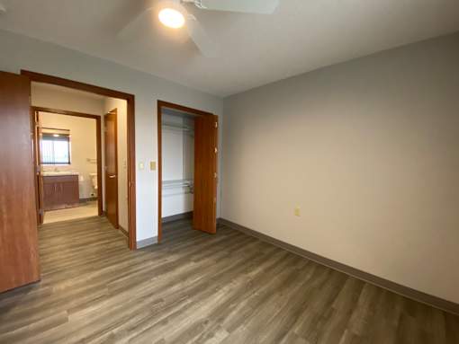 A room with a light brown wooden floor and white walls.