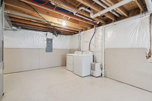 A room with a white wall and a white furnace.
