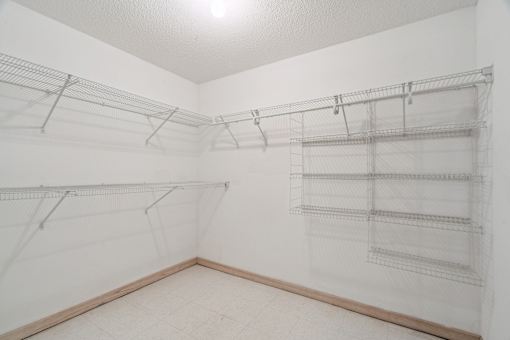 Empty room with wire shelving and white walls.