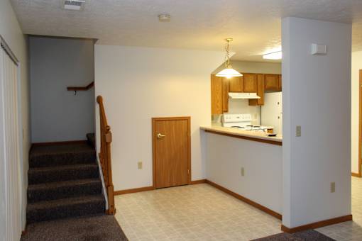 A kitchen area with a staircase leading to the upper floor.