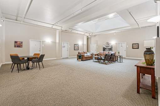 A spacious room with a carpeted floor and furniture.