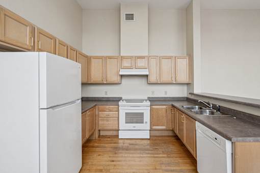 A kitchen with wooden cabinets and a white refrigerator.