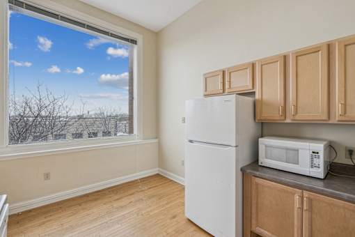 A kitchen with a white fridge and wooden cabinets.