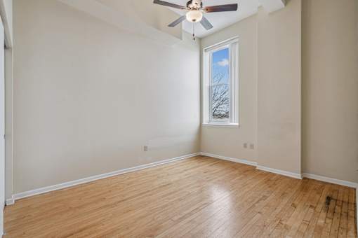 Empty room with a ceiling fan and a window.