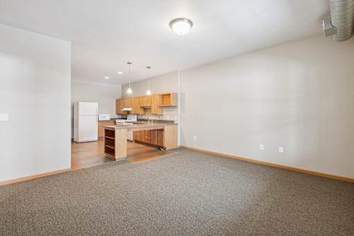 A kitchen with a refrigerator, sink, and cabinets.