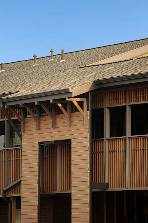 A building with a brown facade and wooden slats on the windows.