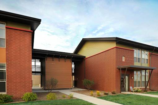 A red brick building with a yellow roof and a covered walkway.