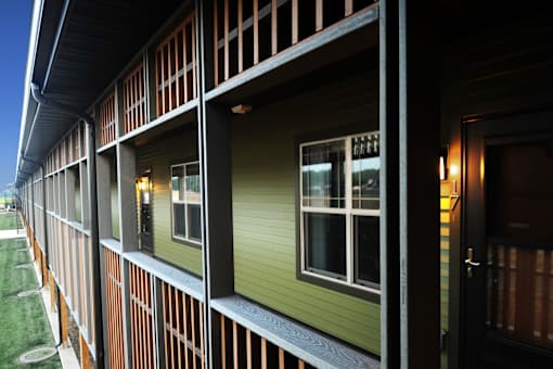 A building with a green siding and a black door.