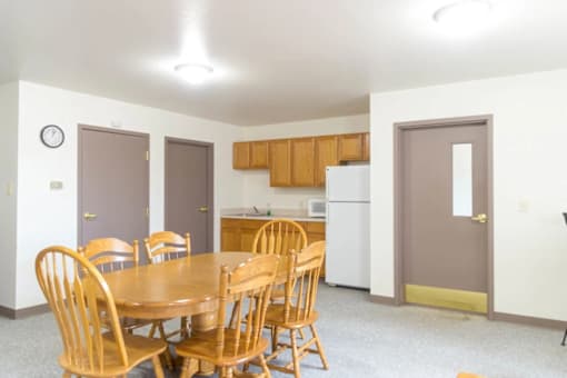 A dining room with a table and chairs.