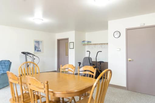A dining room with a wooden table and chairs.