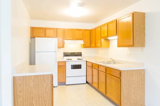 A kitchen with wooden cabinets and white appliances.