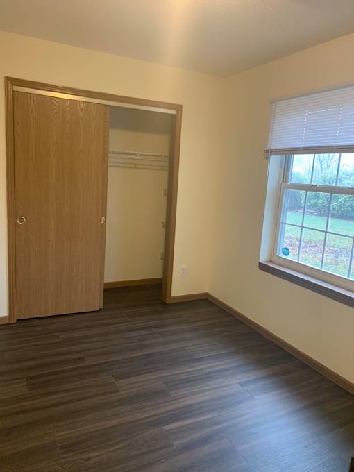 A mirror is mounted on a wall above a wooden door.